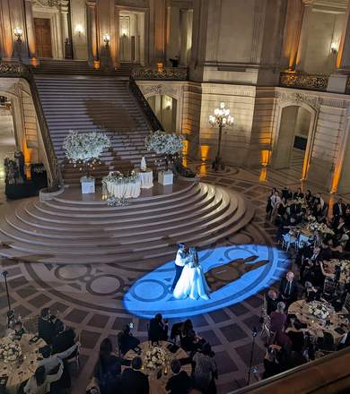 Guests dancing on a wedding reception floor with dramatic lighting